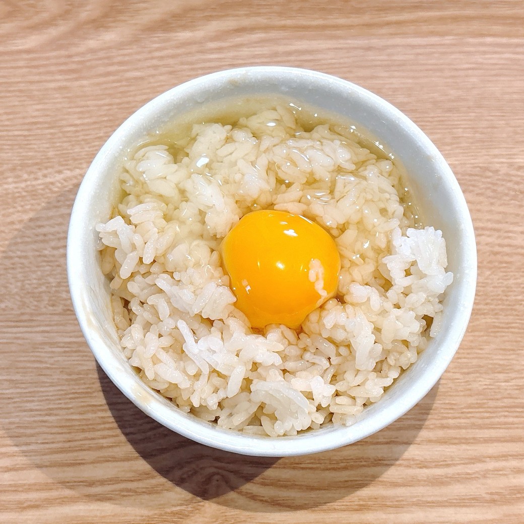 ごはんの真ん中に卵を割り入れる