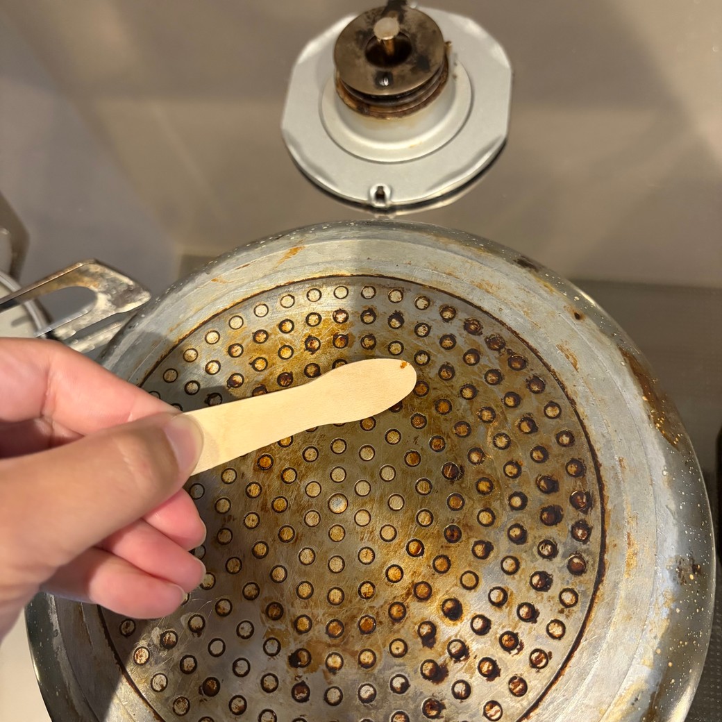 アイススプーンでフライパンの焦げを掃除しているところ