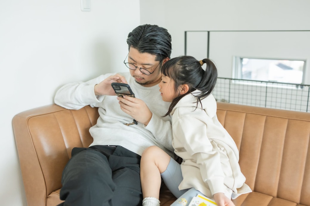 スマホを見る父と娘