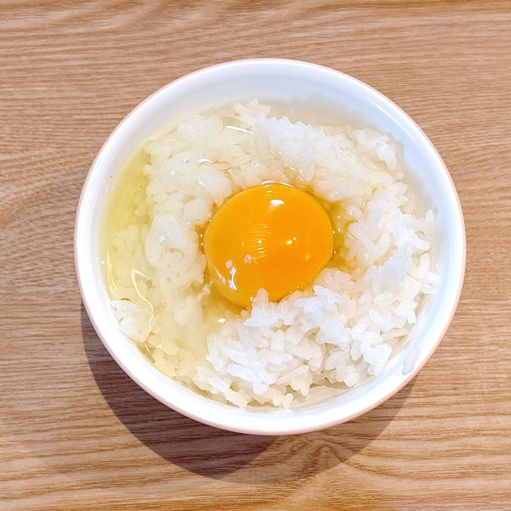 ごはんの真ん中に卵を割る