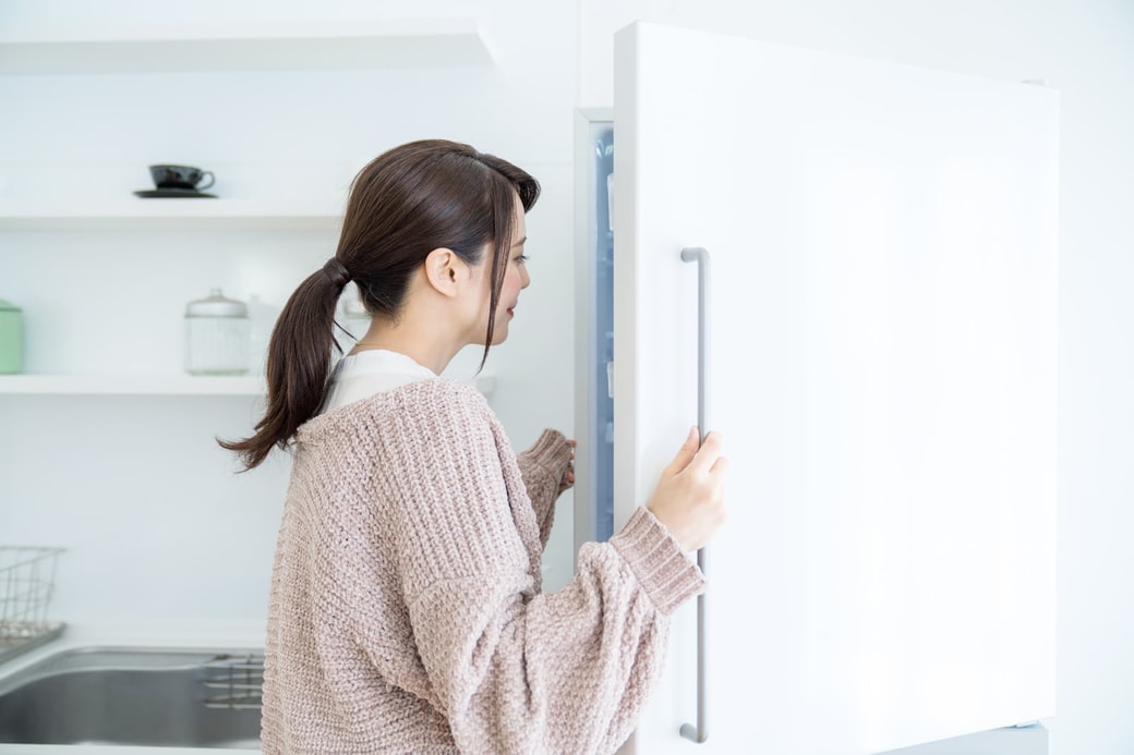 冷蔵庫をチェックする女性