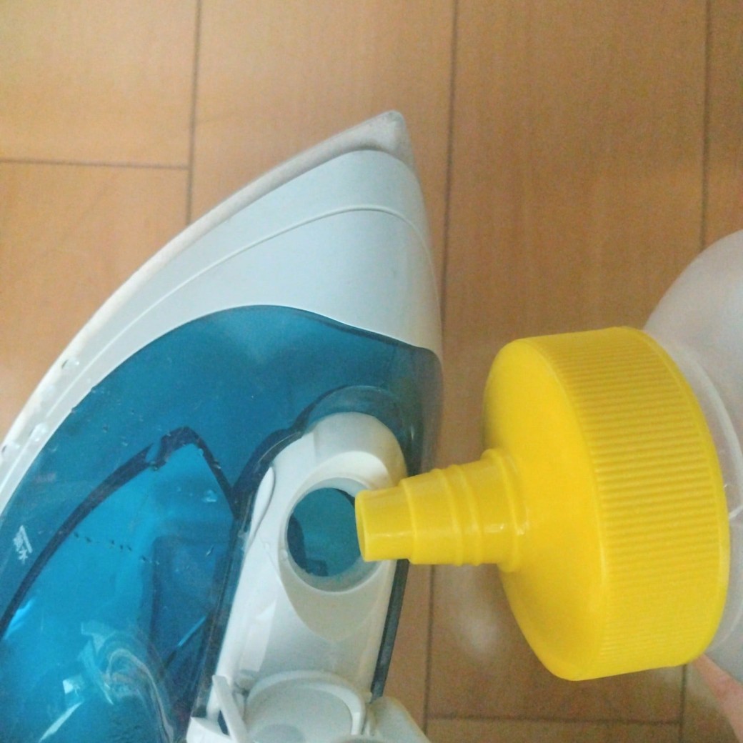 水を入れたはちみつの空容器とスチームアイロン
