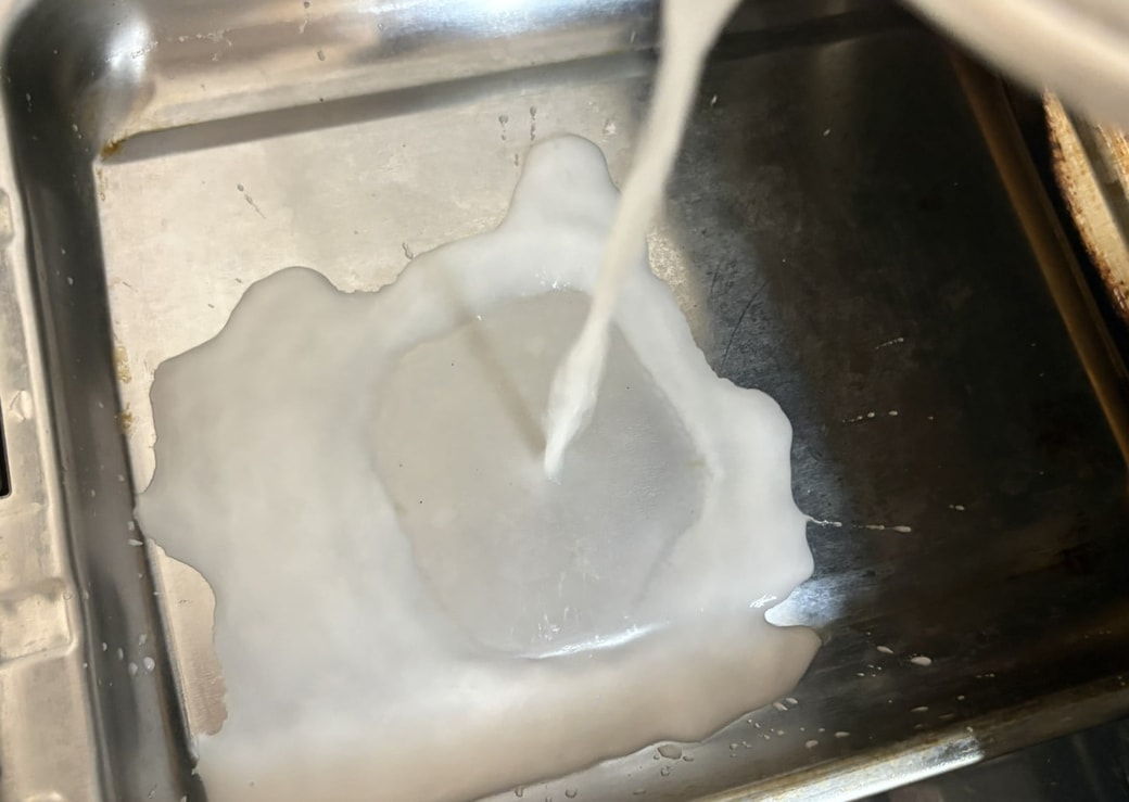 水溶き片栗粉を魚焼きグリルの受け皿に流す様子