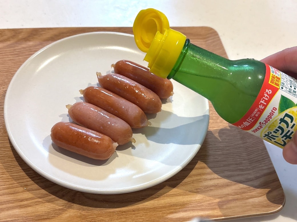 焼けたウインナーにレモン汁をかける