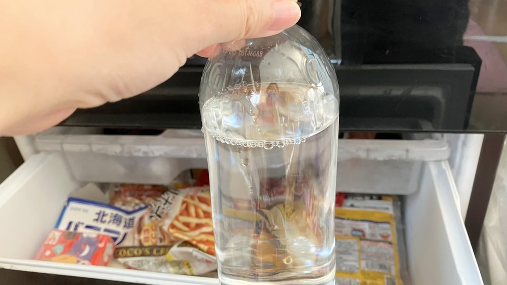 冷凍庫にペットボトルを入れる様子