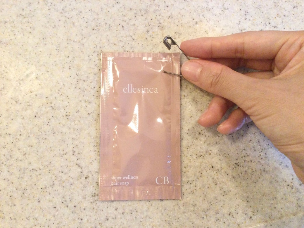 試供品の端に安全ピンを刺す