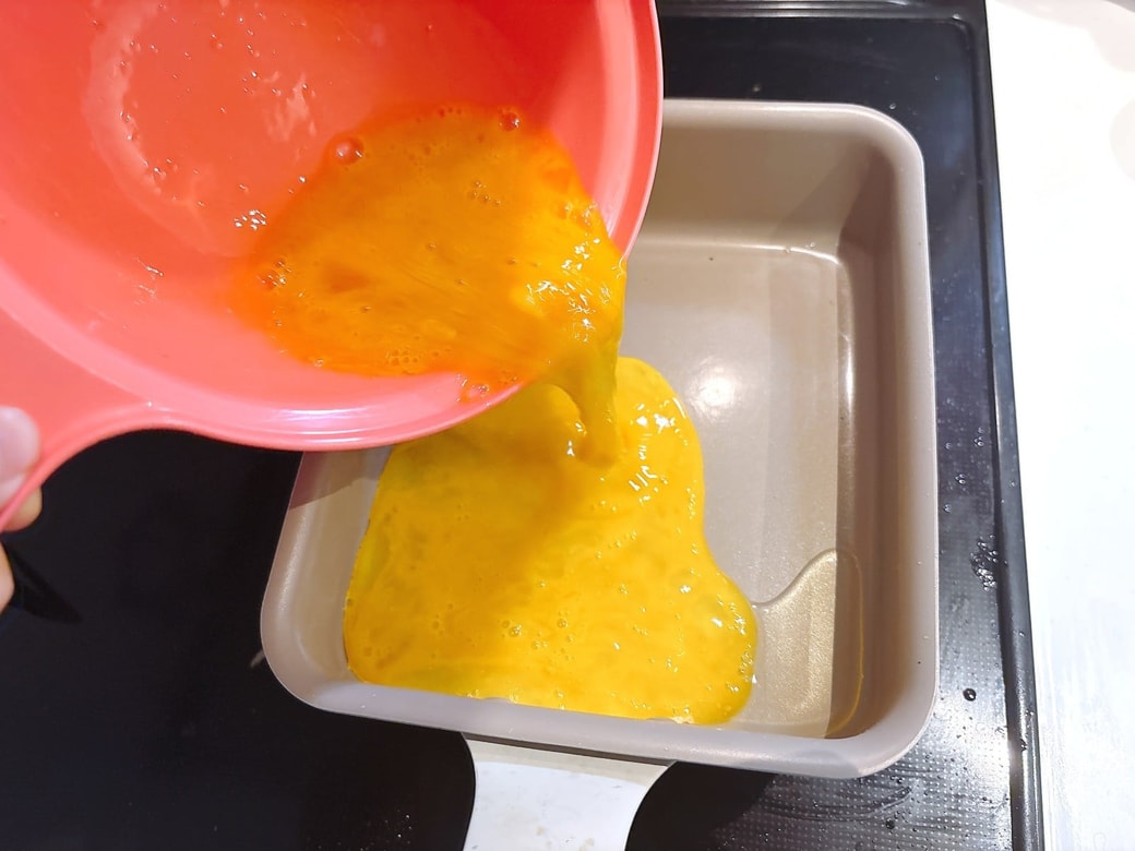 油をひいたフライパンで卵を焼く