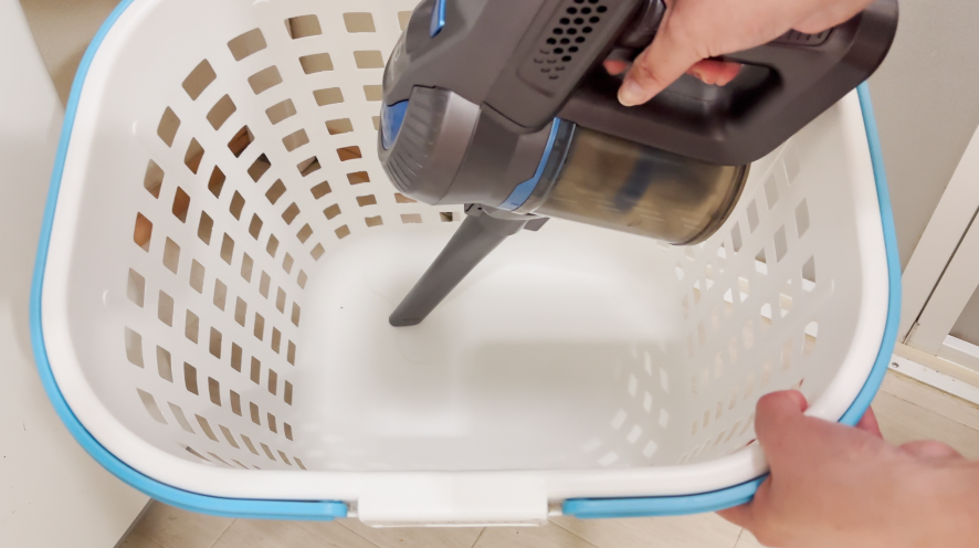 洗濯かごの中を掃除機でゴミを吸い取る
