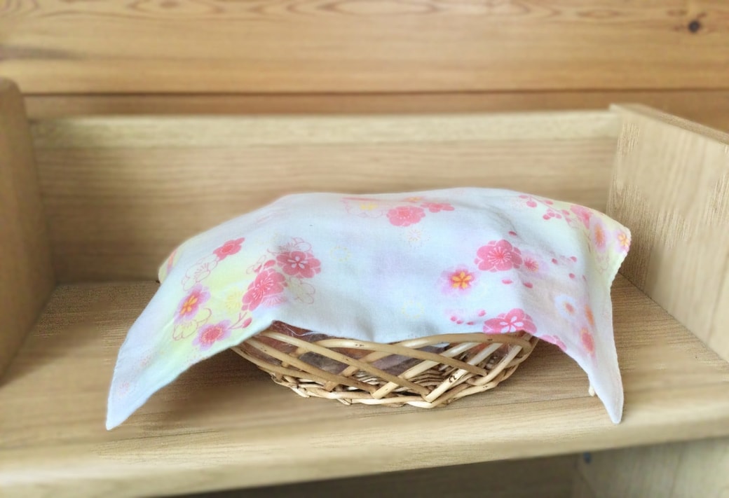 かごに入った果物に手ぬぐいをかぶせる