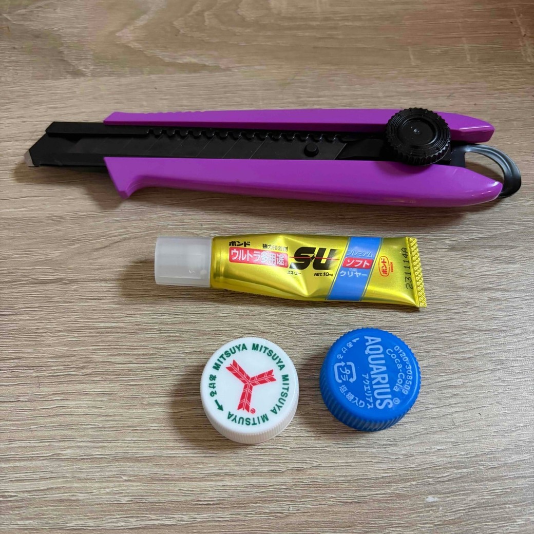 ペットボトルのフタ2つ、カッター、ボンドの写真