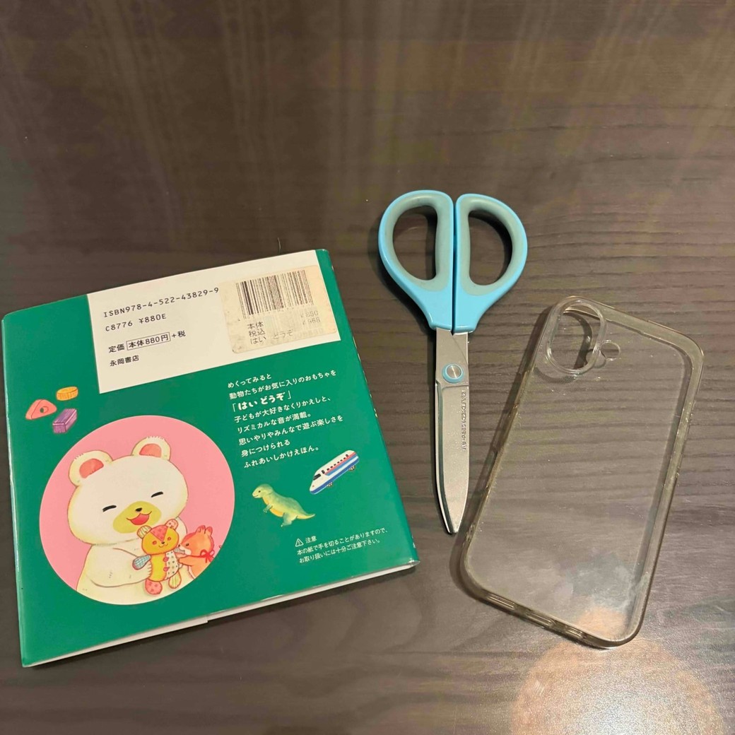 本のカバー、スマホケース、ハサミの写真