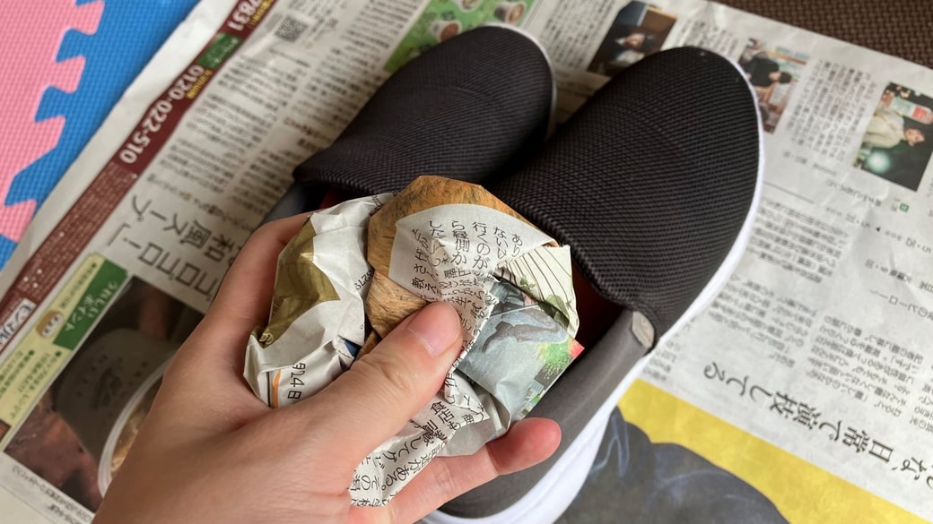 靴に丸めた新聞紙を入れている様子