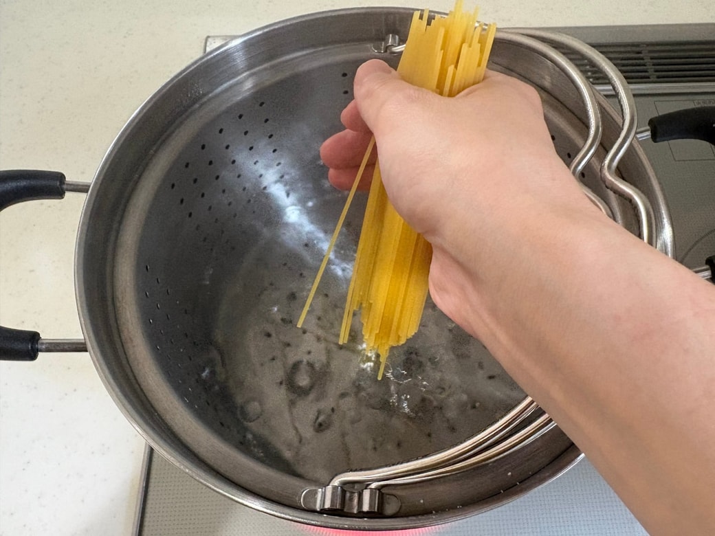 沸騰したお湯にパスタを入れる
