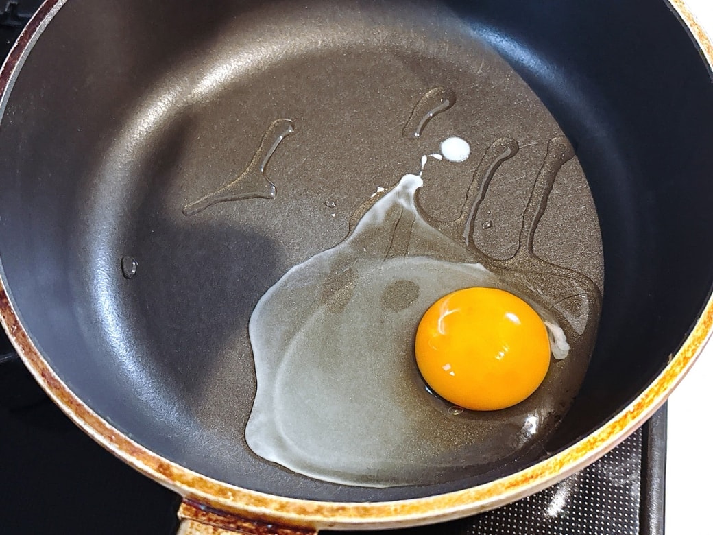 フライパンに油をひいて目玉焼きを作る