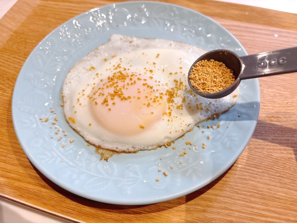目玉焼きを皿に移し、コンソメ顆粒をかける
