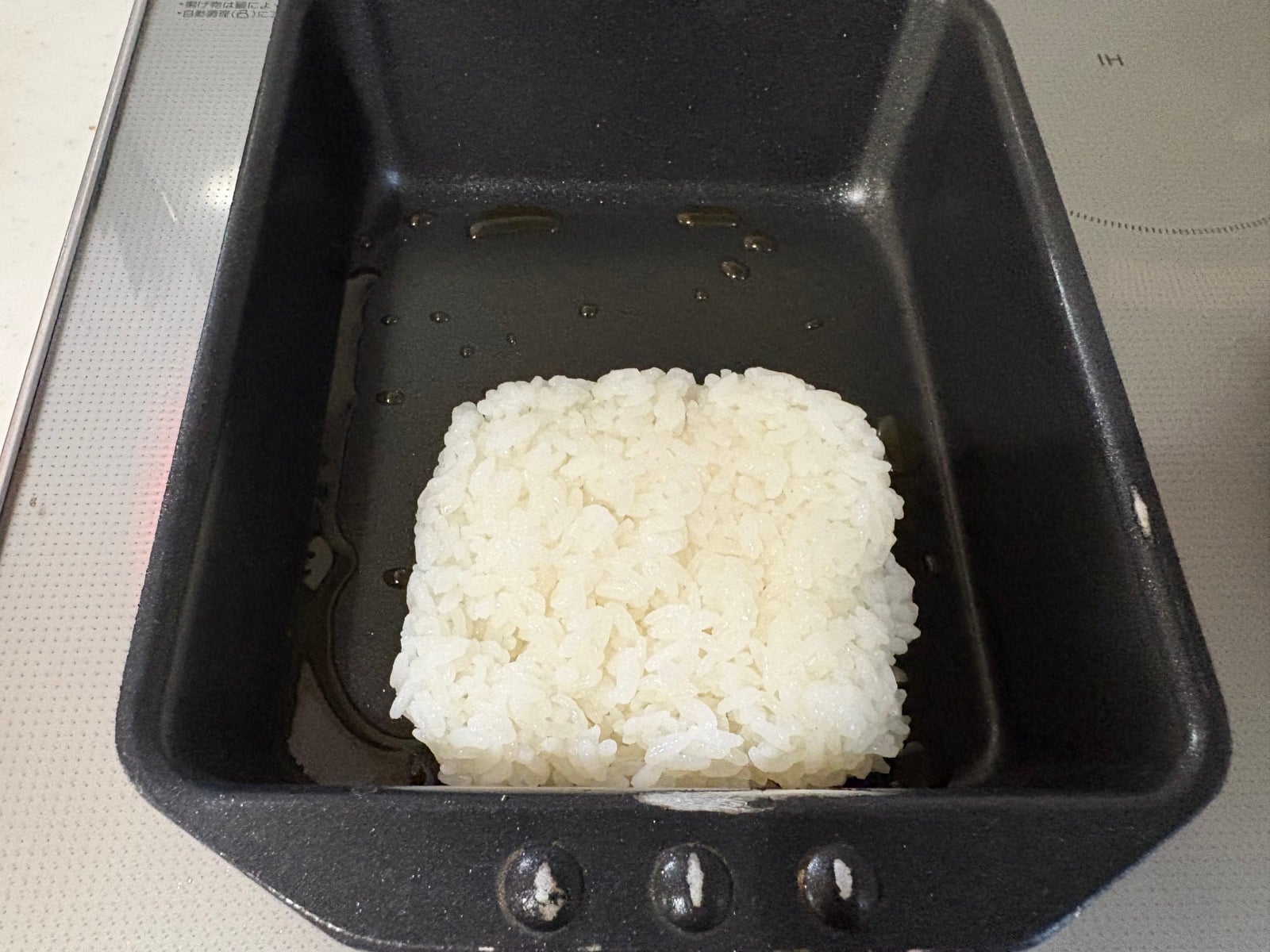 卵焼き器にご飯を入れる