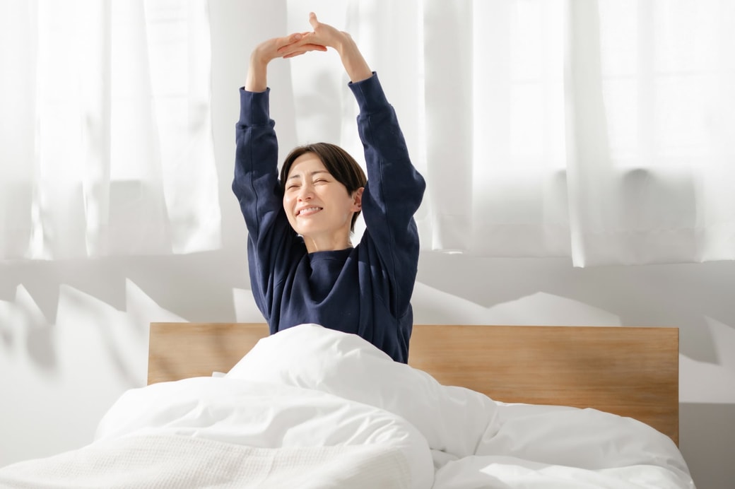 ベッドの上で伸びをする