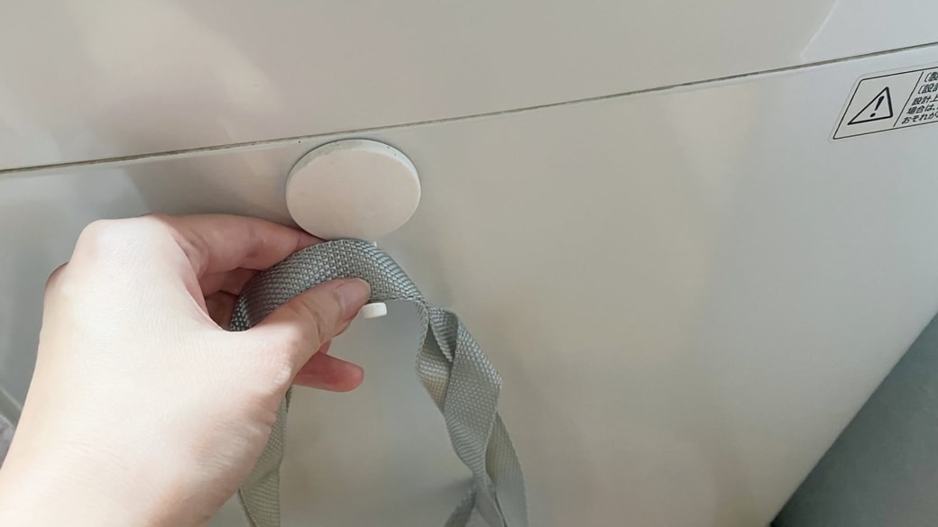洗濯機にフックを取り付けている様子