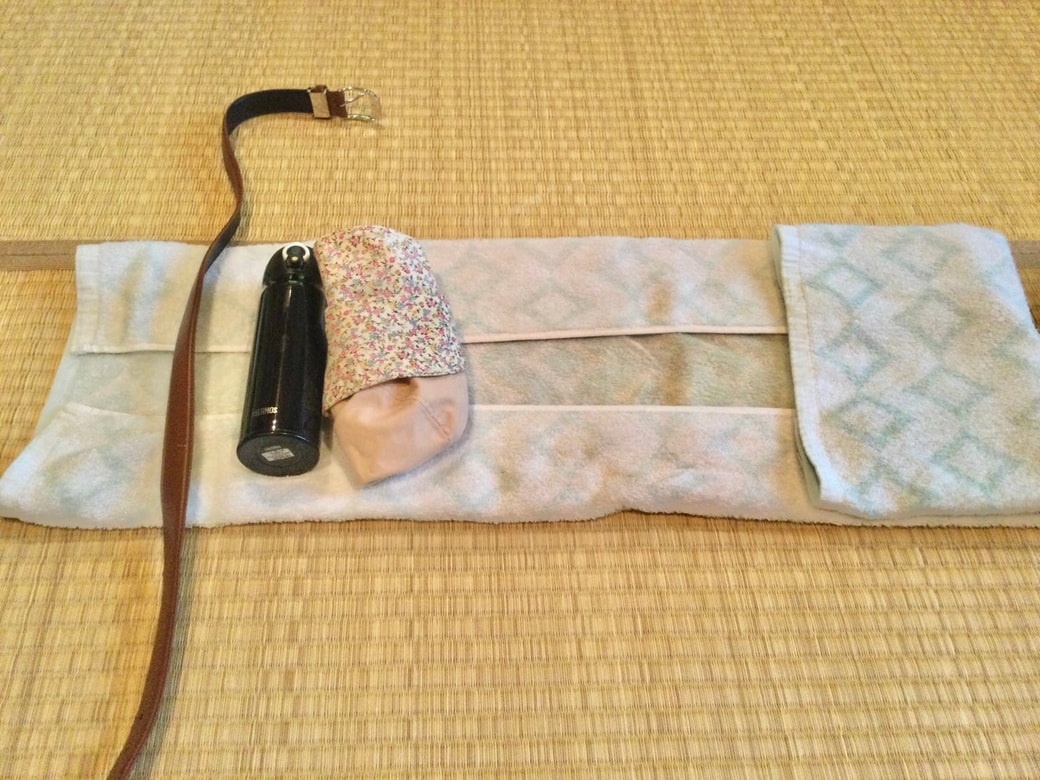 広げたバスタオルに荷物とベルトをのせる