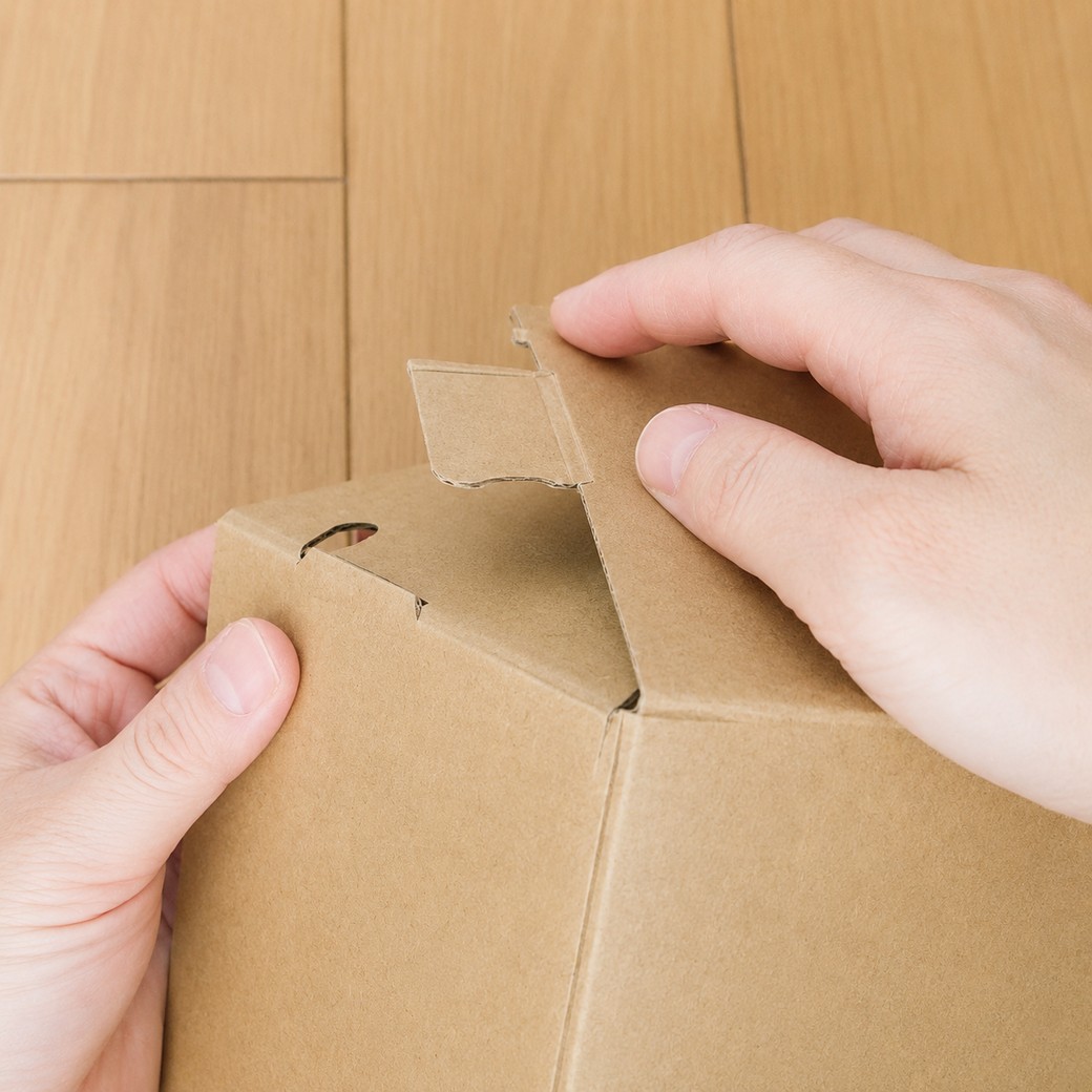 開いた靴の空き箱を箱にする人