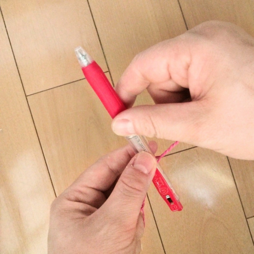 ボールペンにつけた輪ゴムをねじる人