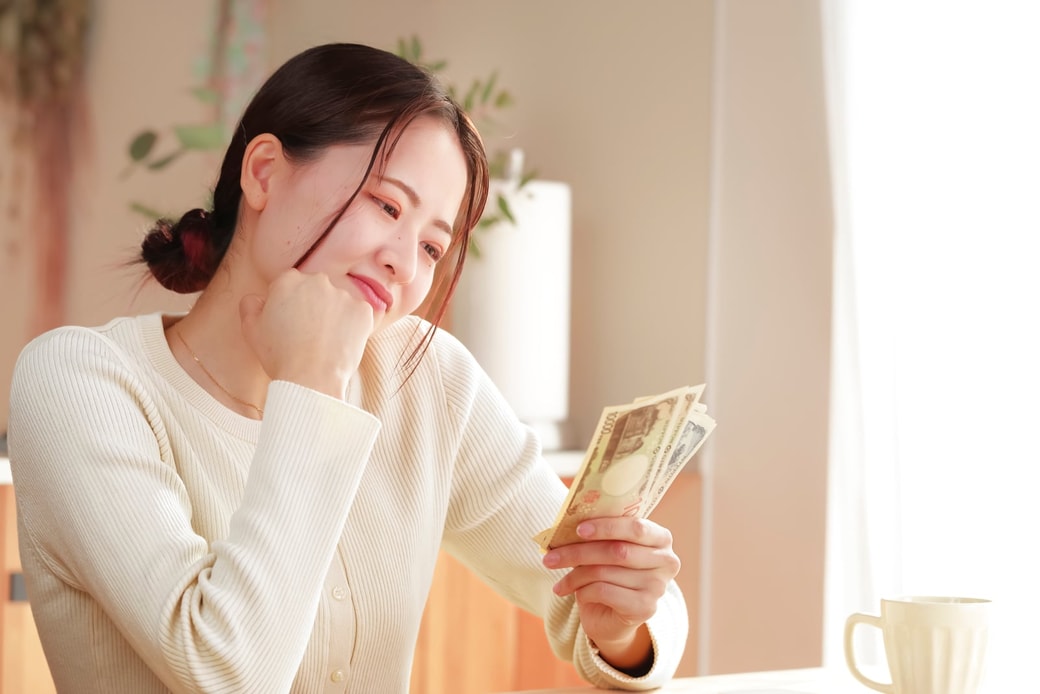 お金を見つめる女性