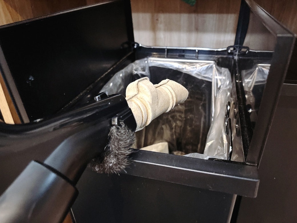ゴミ箱のふちで掃除機を軽くたたくと、触らずに処理できる