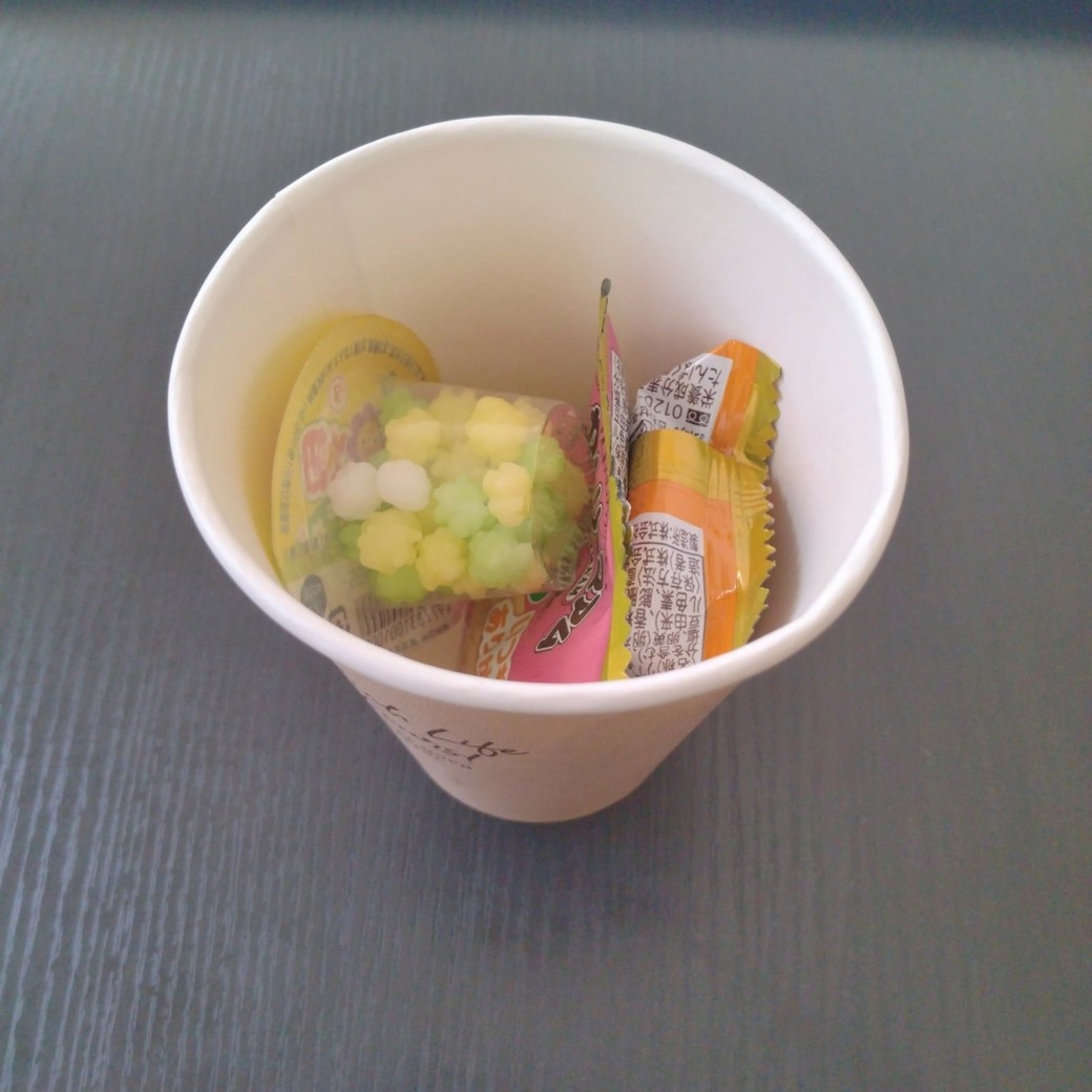個包装のお菓子を入れた紙コップ
