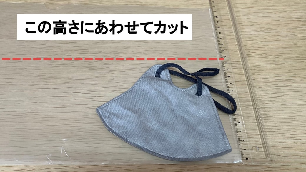 クリアファイルをマスクの高さに合わせている様子