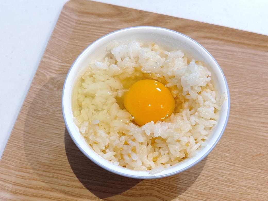 ごはんの真ん中に卵を割り入れる