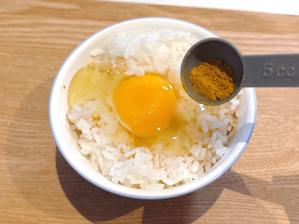 卵かけごはんにカレー粉と醤油をかける