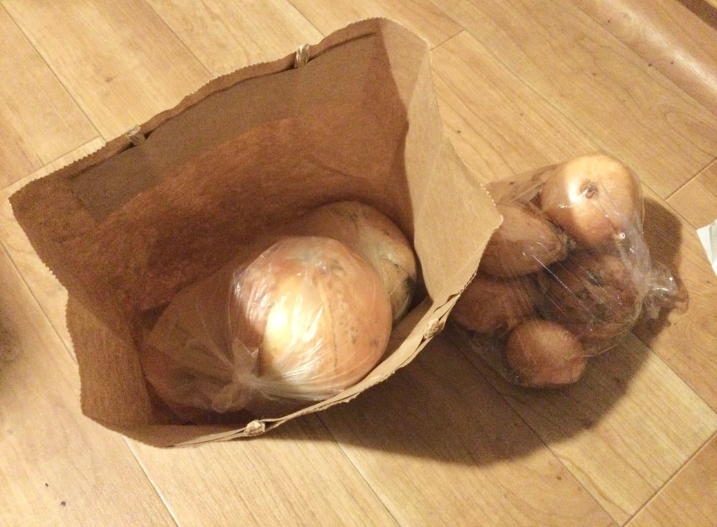 紙袋に玉ねぎを入れる