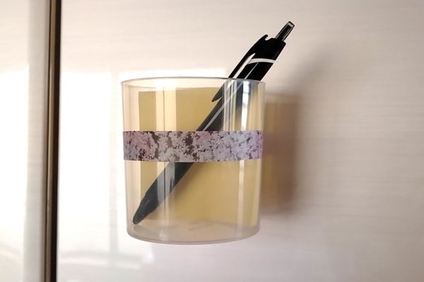 綿棒の空き容器を冷蔵庫のドアに文房具入れとして取り付けた様子