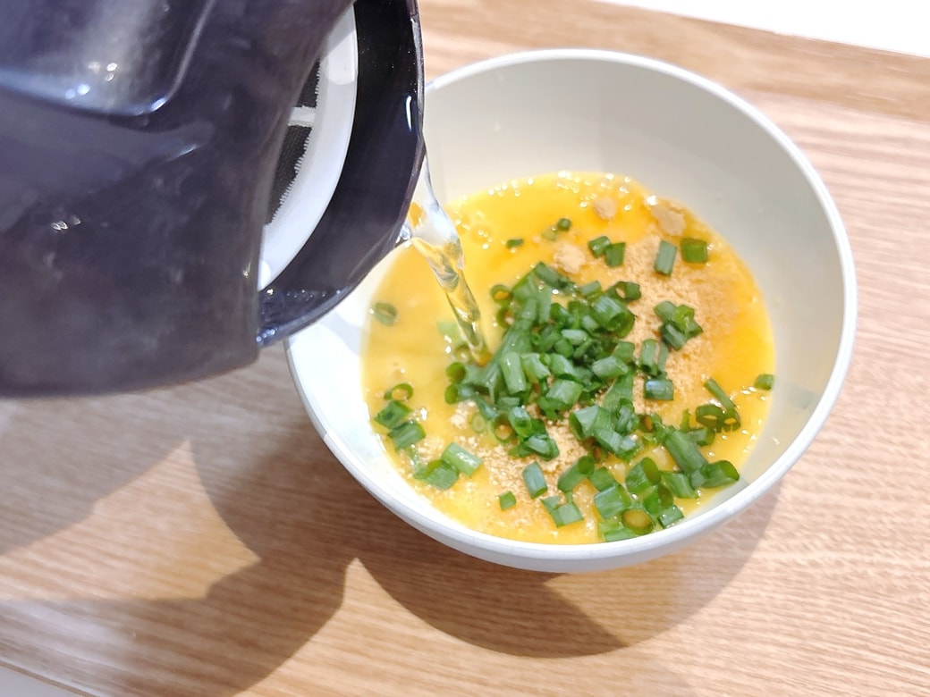 手順2.中華スープの素・生姜チューブ・刻みねぎを加えてお湯を注ぐ