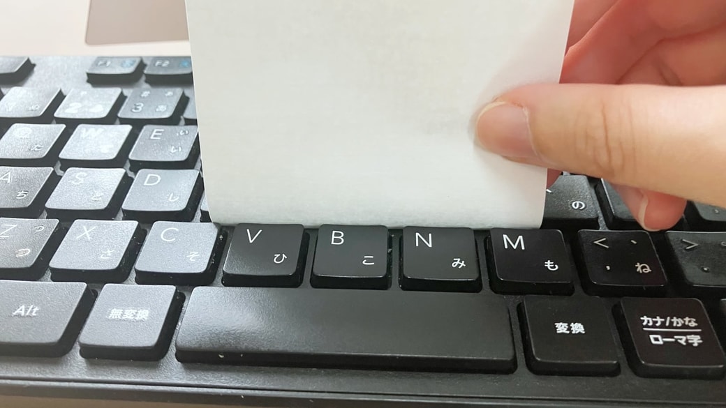 キーボードに付箋を差し込んでいる様子