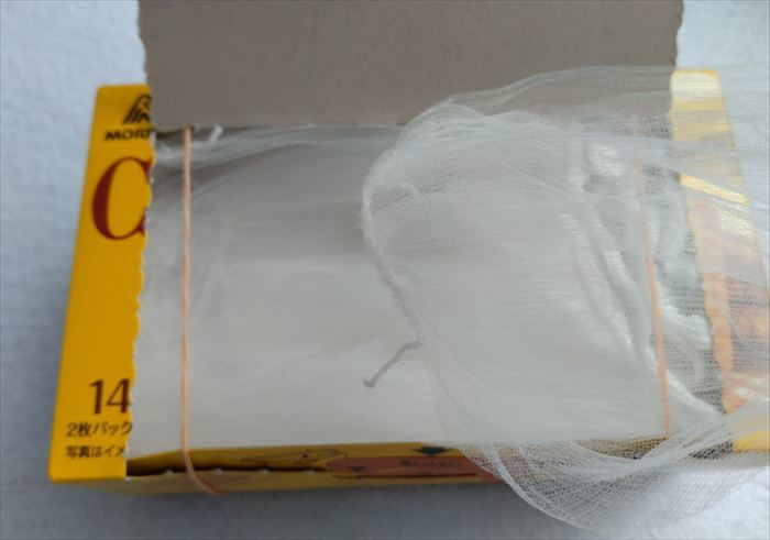 お菓子の箱の両端に輪ゴムをつけて中に水切りネットを入れたら、水切りネットケースが完成！