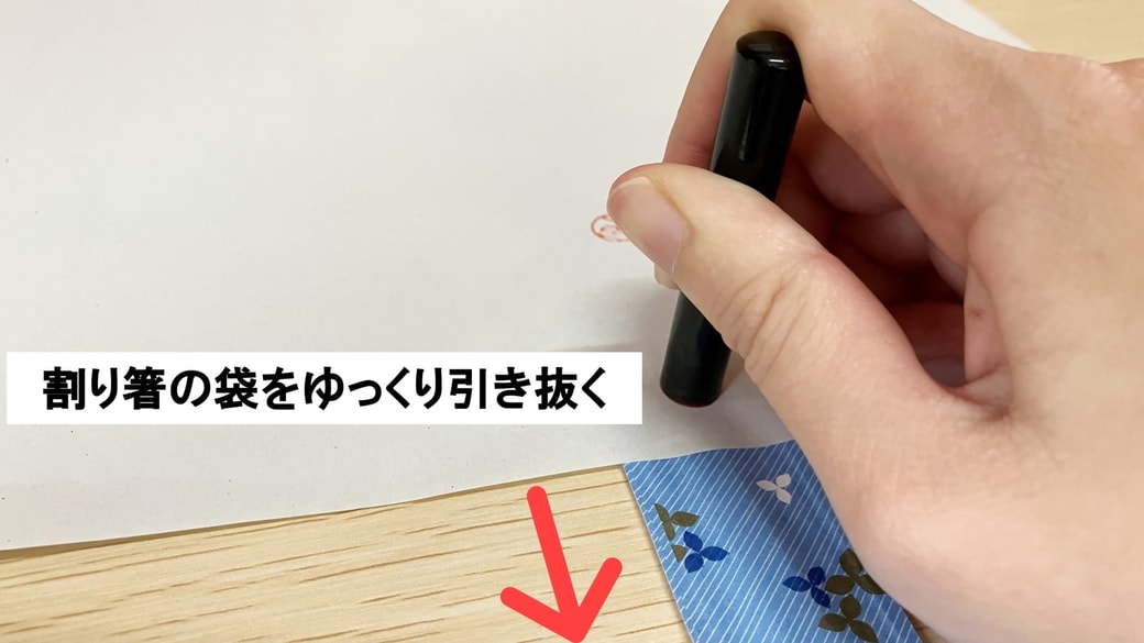 割り箸の袋を引き抜いている様子