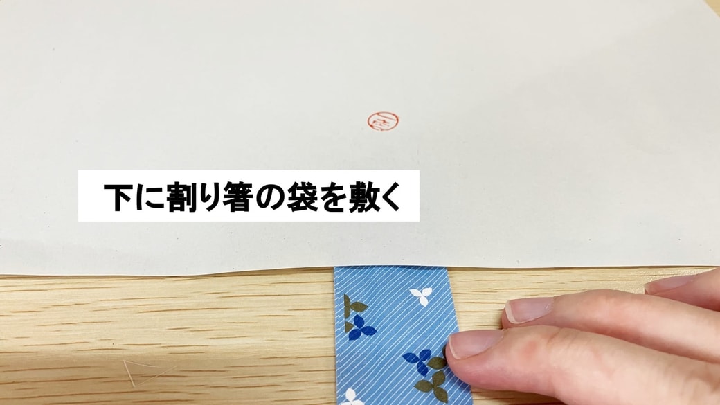 紙の下に割り箸の袋を敷いている様子