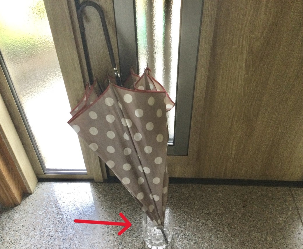 濡れた傘の先端をペットボトルに入れる