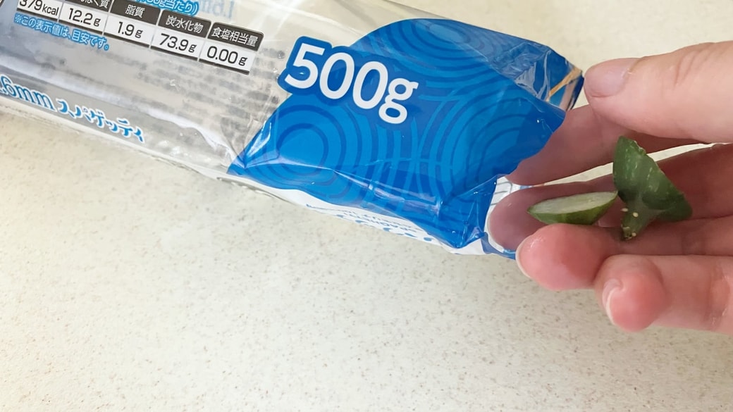 野菜のヘタをパスタの空き袋に入れている様子