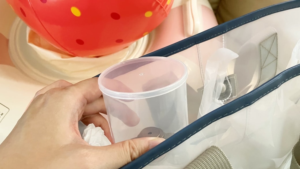 プールバッグへ綿棒の空き容器を入れている様子