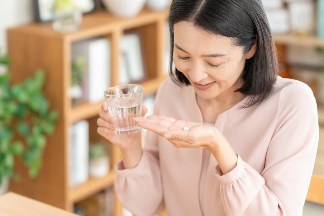 サプリを飲む女性