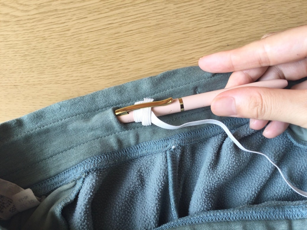 ボールペンに挟んだゴム紐を通す