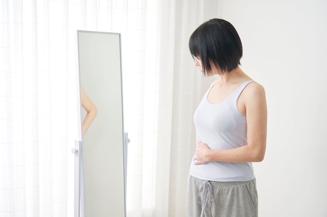 お腹周りを気にする女性