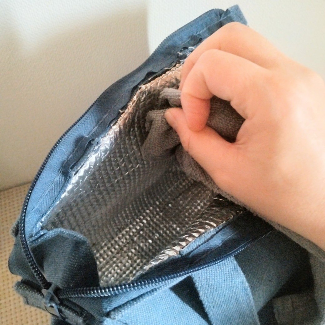 傷んだタオルで保冷バッグをきれいにする人