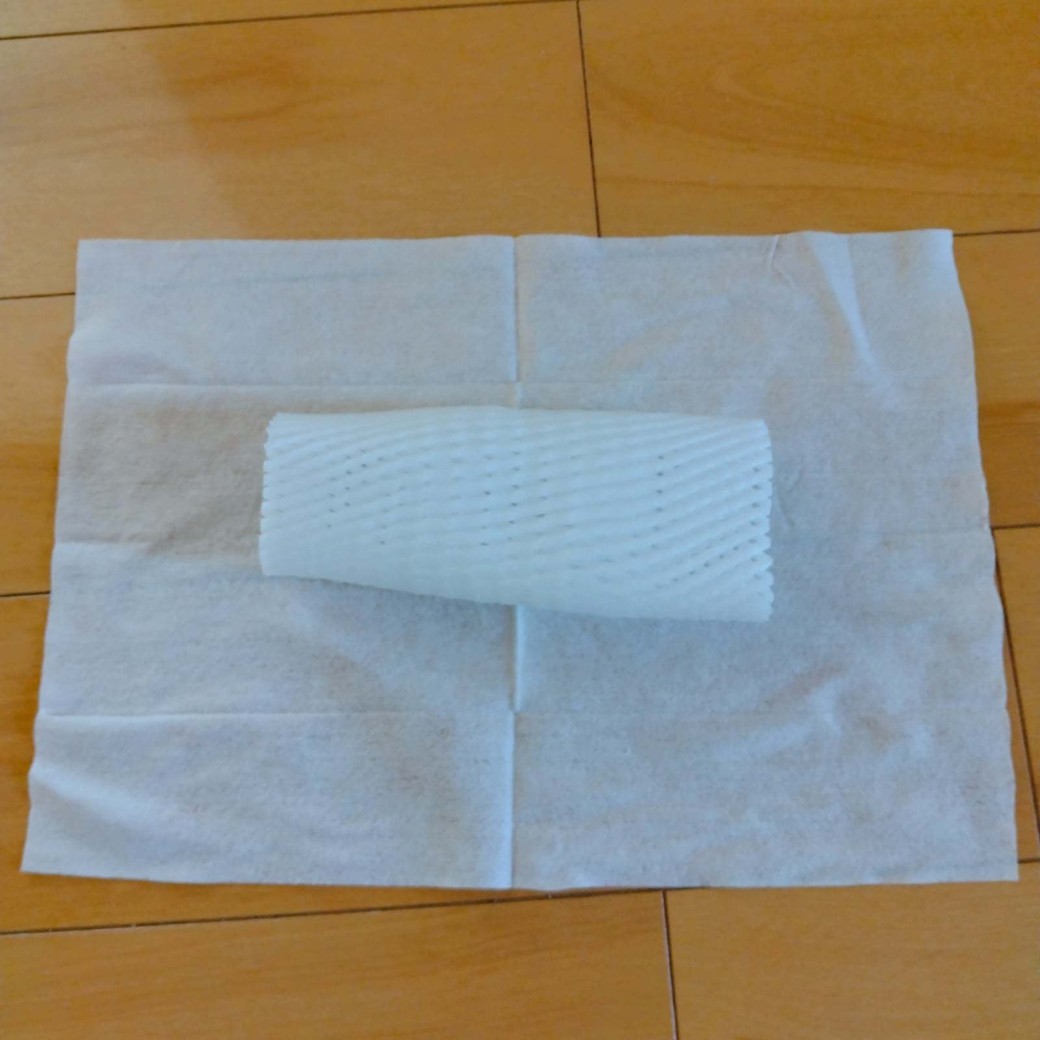 床に掃除シートとフルーツキャップを重ねて置いた様子