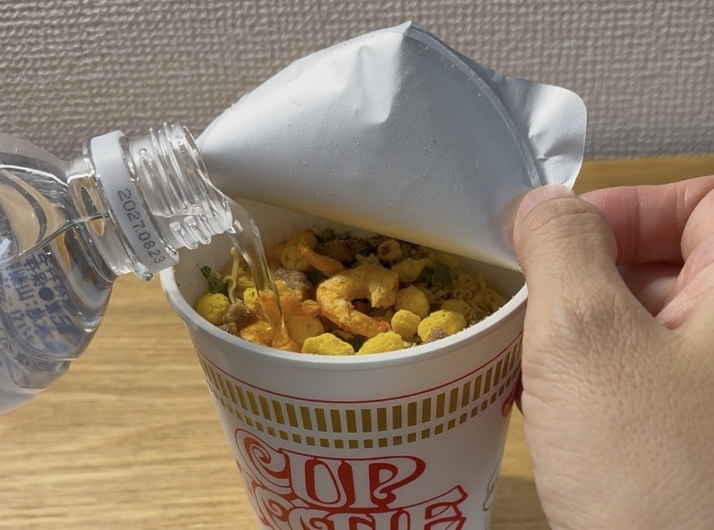 カップヌードルに水を注ぐ様子