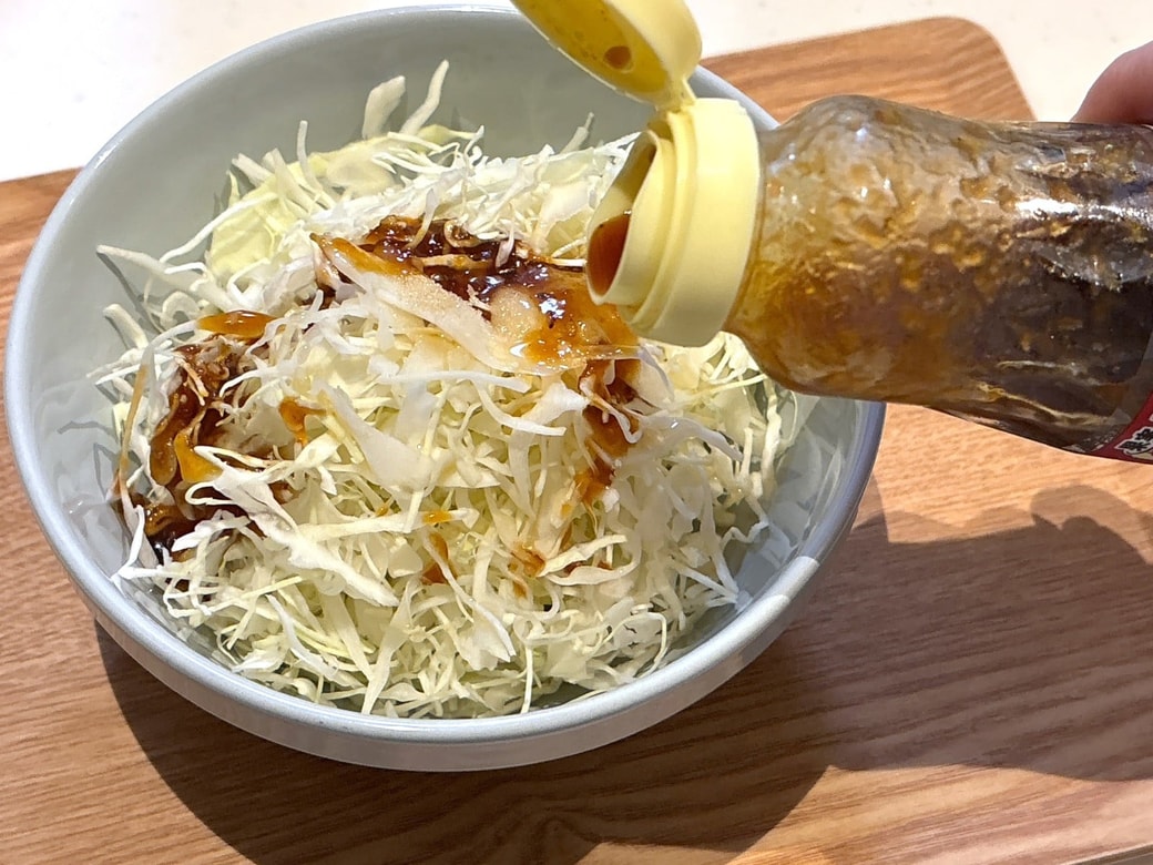 手順1.カットキャベツをボウルに入れ、焼き肉のたれ・にんにくチューブ・砂糖・ごま油をすべて入れて混ぜる