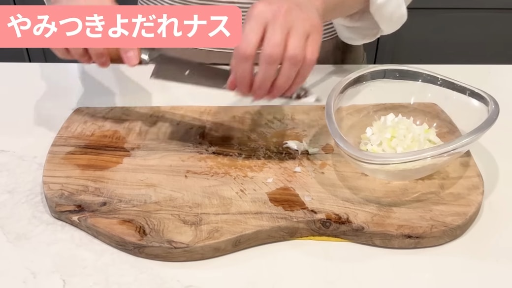 みじん切りにしたねぎをボウルに入れる人