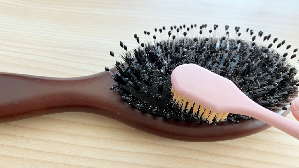 歯ブラシをヘアブラシのお手入れに使用している様子